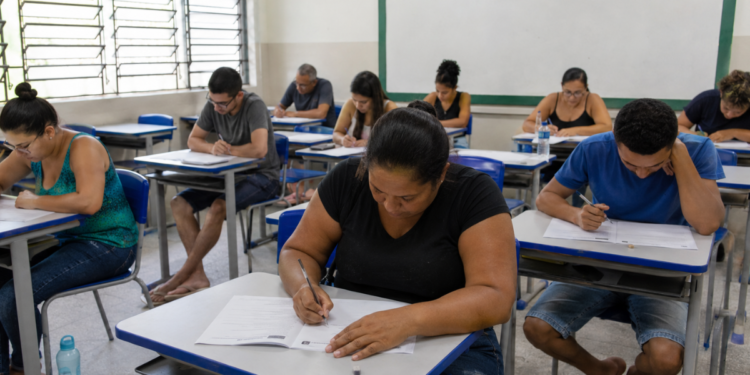 Participantes fazem a prova do Encceja em sala de aula de escola pública.