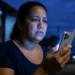 Mulher usando iPhone durante chamada de emergência, representando o recurso de envio de imagens ao vivo em ocorrências pelo 190.