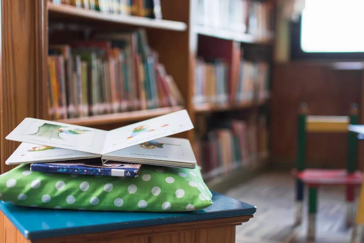 Livros didáticos sobre mesa em biblioteca escolar durante processo de escolha do PNLD.