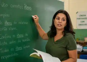 Professora explica no quadro o uso correto da palavra itens em português
