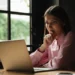 Mulher consulta informações em notebook sobre possíveis fraudes em concursos públicos.