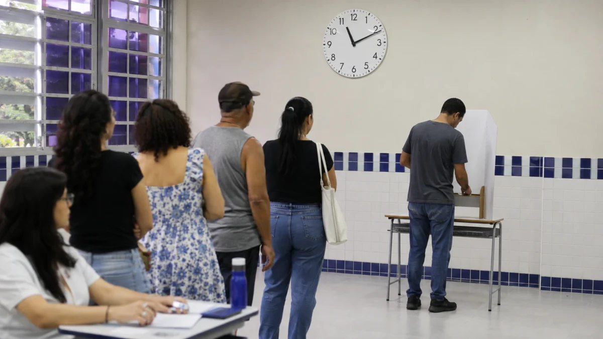 Eleitores aguardando em fila para votar dentro de local de votação