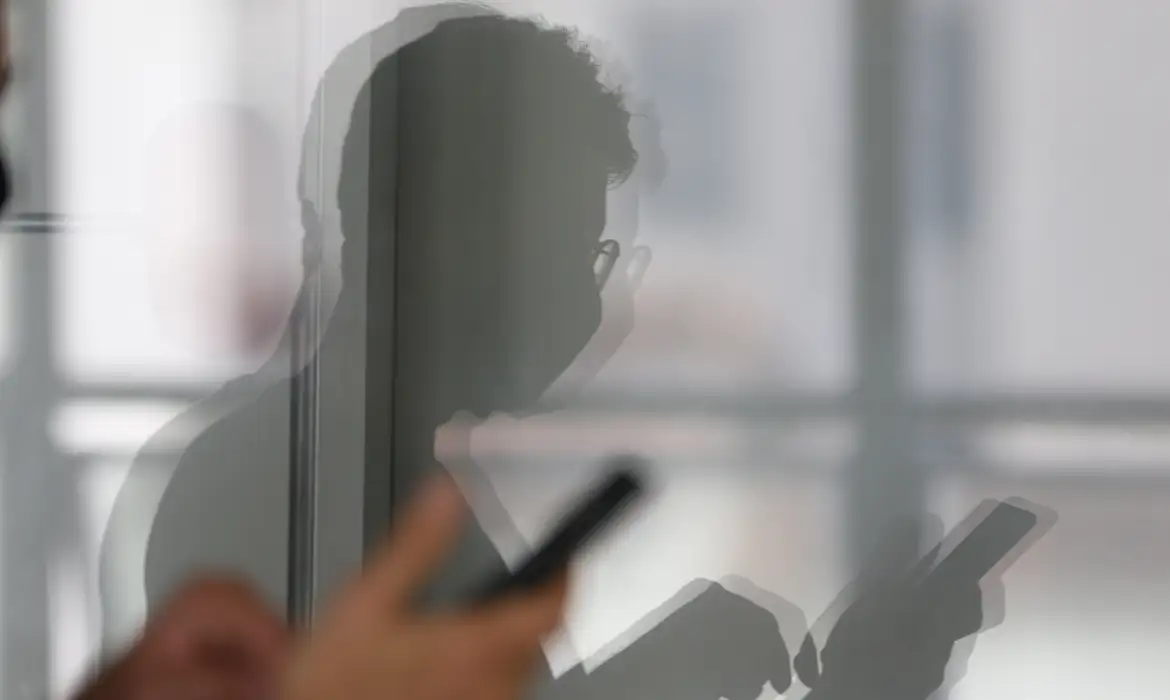 Pessoa usando celular em imagem que representa cuidados com golpes e segurança em sites de apostas.