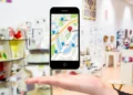 Celular com mapa digital e marcadores de localização sobre a mão de uma pessoa.