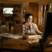 Mulher trabalhando em home office diante do computador durante uma refeição.