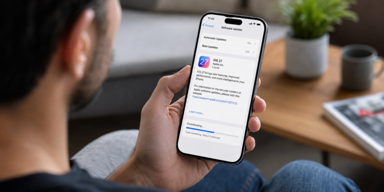 Pessoa segurando iPhone exibindo tela de download do iOS 27, a nova atualização anunciada na WWDC 2026.