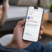 Pessoa segurando iPhone exibindo tela de download do iOS 27, a nova atualização anunciada na WWDC 2026.