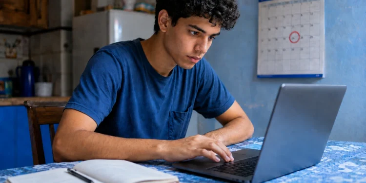 Jovem acessa o notebook, representando a inscrição e a conferência das datas do vestibular da Fuvest.