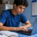 Jovem acessa o notebook, representando a inscrição e a conferência das datas do vestibular da Fuvest.
