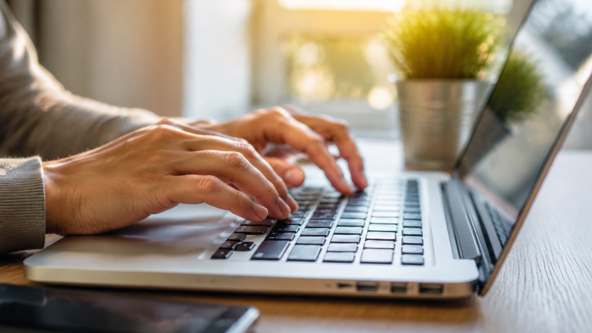 Pessoa realizando inscrição online em concurso público pelo notebook.