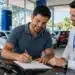 Brasileiro assina contrato de financiamento de veículo em uma concessionária durante o processo de aquisição de um automóvel, representando a contratação pelo programa Move Brasil 2026.