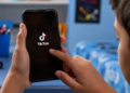 Criança acessa o TikTok pelo celular em contexto de proteção de dados de menores.