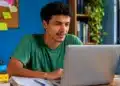 Jovem consulta o resultado da nova chamada do Prouni 2026 pelo notebook em um ambiente de estudos.