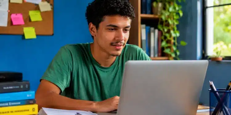 Jovem consulta o resultado da nova chamada do Prouni 2026 pelo notebook em um ambiente de estudos.