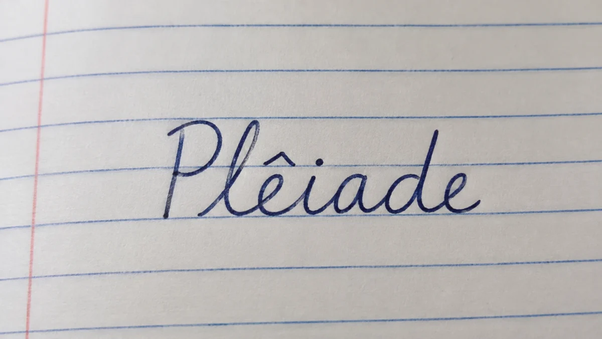 Palavra plêiade escrita em caderno, destacando a origem e a grafia do termo usado na língua portuguesa.