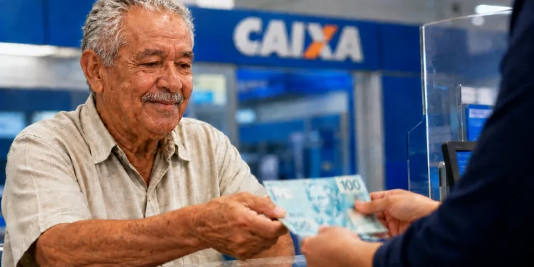 Idoso recebe dinheiro em agência bancária representando os pagamentos do INSS de agosto para beneficiários que recebem até um salário mínimo.