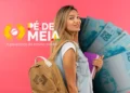 Imagem mostra uma estudante com mochila e materiais escolares ao lado da identidade visual do programa Pé-de-Meia, representando o pagamento da parcela de agosto do benefício para alunos do ensino médio público.