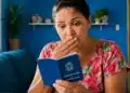 Mulher analisando carteira de trabalho com expressão de surpresa sobre direitos previdenciários do INSS durante período de graça