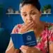 Mulher analisando carteira de trabalho com expressão de surpresa sobre direitos previdenciários do INSS durante período de graça