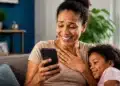 Mãe consulta celular após receber informação sobre pagamento de pensão por Pix