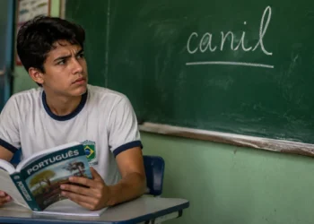 Estudante brasileiro observa a palavra "canil" escrita no quadro durante aula de português