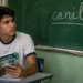 Estudante brasileiro observa a palavra "canil" escrita no quadro durante aula de português