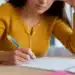Candidata realizando prova escrita da Prova Nacional Docente (PND) 2026 com questão discursiva manuscrita.