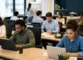Trabalhadores em ambiente corporativo durante o expediente, representando o possível adiamento do fim da escala 6x1 para depois das eleições de 2026.