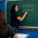 Professora escreve as palavras "presar" e "prezar" no quadro durante aula de língua portuguesa