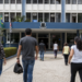 Pessoas caminham em direção a uma prefeitura, em referência aos processos seletivos com vagas de nível médio em Minas Gerais.