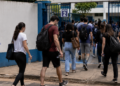 Candidatos chegam ao local de prova do processo seletivo do IBGE com mochilas e materiais para realização do exame.