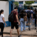Candidatos chegam ao local de prova do processo seletivo do IBGE com mochilas e materiais para realização do exame.