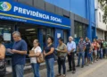 Fila de segurados em frente a uma agência do INSS, representando a redução da fila de pedidos.