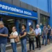 Fila de segurados em frente a uma agência do INSS, representando a redução da fila de pedidos.