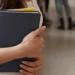 Estudante segura cadernos em ambiente escolar, representando a reaplicação do Encceja 2026 em outubro.