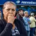 Pessoas aguardam atendimento em frente à Previdência Social, representando a tentativa do governo de acelerar a análise de benefícios do INSS.