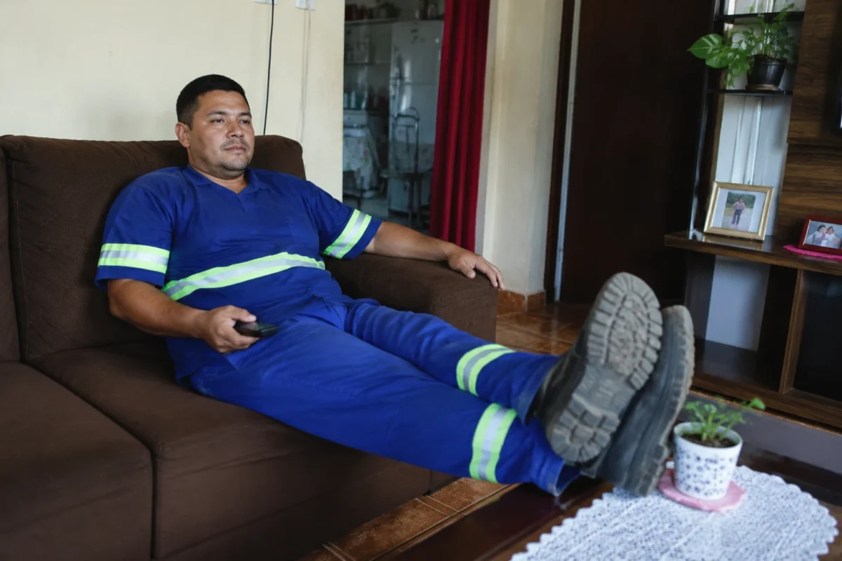Trabalhador descansa em casa após a jornada de trabalho, representando a redução da jornada para 40 horas semanais.