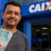 Trabalhador segura cédulas em frente a uma agência da Caixa, representando o fim do período de saque-aniversário do FGTS para os nascidos em junho.