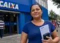 Mulher segura documentos em frente a uma agência da Caixa, representando a liberação do Saque Calamidade do FGTS em São Paulo.