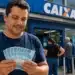 Homem segura notas de R$ 100 em frente a uma agência da Caixa, representando o saque do FGTS de R$ 6.220 a partir de 14 de agosto.