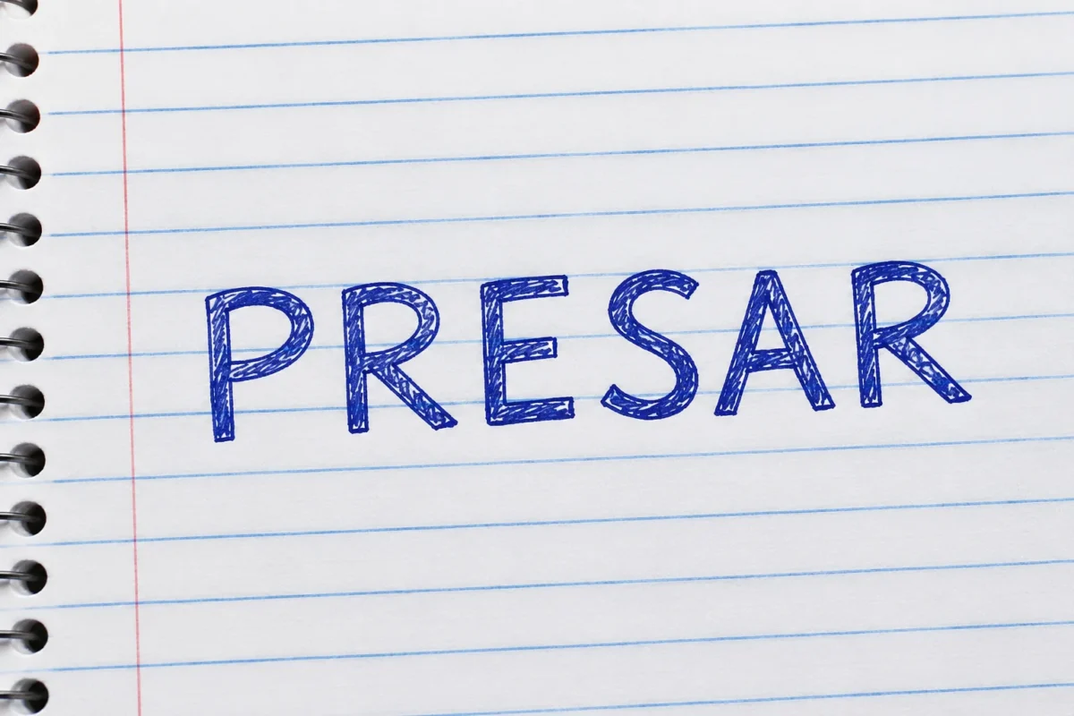 Palavra "presar" escrita em caderno, representando o significado de capturar ou aprisionar