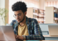 Pessoa estudando com notebook para concursos e oportunidades na área da educação.