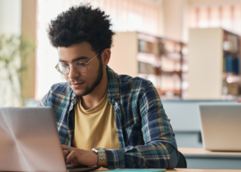 Pessoa estudando com notebook para concursos e oportunidades na área da educação.