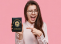 Mulher jovem sorrindo, piscando e apontando para CNDB com orgulho.