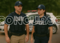 Dois agentes da Guarda Municipal uniformizados em frente a viatura e grande texto “CONCURSO”