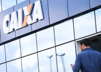 Fachada da agência Caixa Econômica Federal com homem chegando.