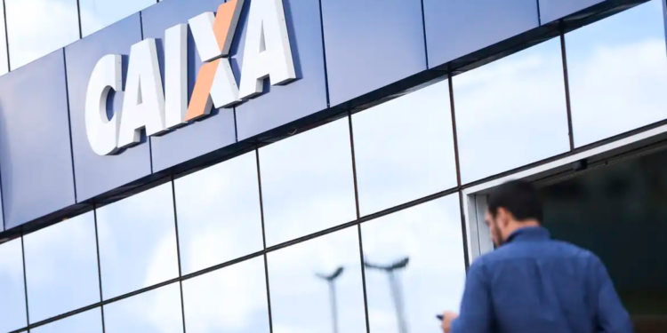 Fachada da agência Caixa Econômica Federal com homem chegando.