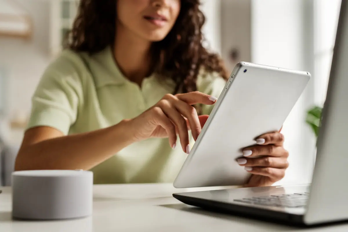 Candidata consulta informações de concursos públicos em tablet durante preparação para seleções com inscrições abertas e salários de até R$ 12 mil.