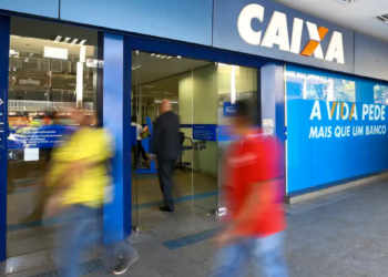 Fachada de agência da Caixa Econômica Federal com pessoas em movimento.