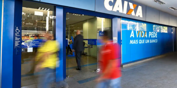 Fachada de agência da Caixa Econômica Federal com pessoas em movimento.